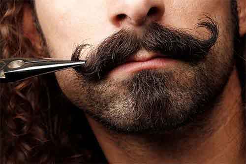 barbier taillant une moustache guidon homme au ciseau